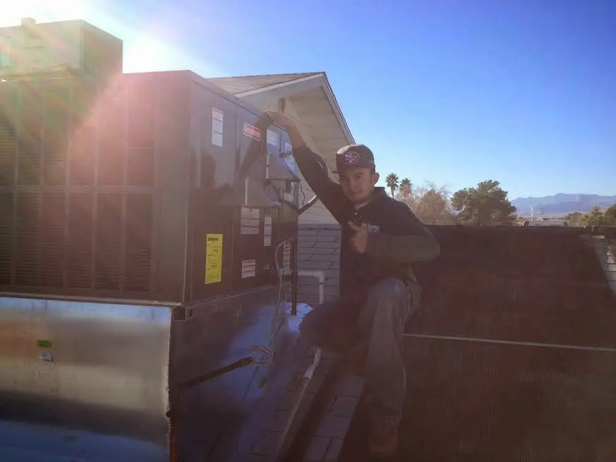 HVAC technician performing AC Tune-Up on a rooftop unit in Benton Park